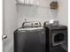 Functional laundry room with washer, dryer, and overhead shelving at 197 Stafford Ln, Villa Rica, GA 30180