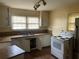 Kitchen with white cabinets, stove, and double sink at 6848 Church St, Lithonia, GA 30058