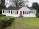 White house with red door and black shutters at 6848 Church St, Lithonia, GA 30058