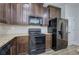 Kitchen with black appliances and dark wood cabinets at 8728 Danley Dr, Douglasville, GA 30135