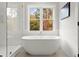 Elegant bathroom with soaking tub, glass shower, and large window at 3794 Wynn Walk, Brookhaven, GA 30341