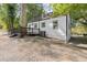 White cottage with deck, large tree, and gravel driveway at 3775 Clairmont Rd, Chamblee, GA 30341