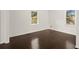 Empty bedroom with dark hardwood floors and two windows at 3775 Clairmont Rd, Chamblee, GA 30341