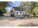 Charming white cottage with a deck, surrounded by lush trees at 3775 Clairmont Rd, Chamblee, GA 30341
