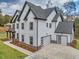 White two-story farmhouse with gray roof and attached garage at 1387 Mineral Springs Rd, Hoschton, GA 30548
