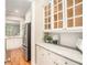 Bright kitchen with white cabinets, glass-front upper cabinets, stainless steel appliances, and granite counters at 5123 Peachtree Rd, Chamblee, GA 30341