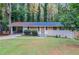 Brick ranch home with carport, needing renovations, set on a grassy lot at 2648 Cavalier Dr, Decatur, GA 30034