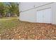 White double doors lead into a spacious basement, with surrounding yard covered in autumn leaves at 117 Neal Ave, Stockbridge, GA 30281