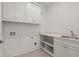 Laundry room with white cabinets, sink, and shelving at 2635 Yellowstone Farm Dr, Cumming, GA 30028