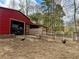 Red barn with animal enclosures, ATV, and free-roaming chickens at 375 Campground Rd, Waco, GA 30182