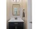 Modern powder room featuring a dark vanity, white countertop and sleek mirror at 3333 Castleberry Village Cir, Cumming, GA 30040