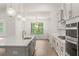 Modern kitchen with white cabinets, quartz countertops, and stainless steel appliances at 3719 Tielman St, Snellville, GA 30078