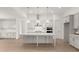 Modern kitchen with white cabinets, quartz countertops, and a large island at 3719 Tielman St, Snellville, GA 30078