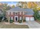 Brick two-story house with a three-car garage and manicured landscaping at 5013 Kendall Nw Sta, Acworth, GA 30102