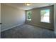 Spacious bedroom with gray carpeting and two windows at 3402 Wild Clary Ct, Buford, GA 30519