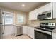 Modern kitchen featuring white cabinets, granite countertops, and stainless steel appliances at 1790 Ledo Ave, Decatur, GA 30035