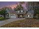 House exterior at dusk featuring a two-car garage and stone accents at 114 Arborwood Way, Temple, GA 30179