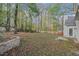 Large backyard with trees and a stone retaining wall at 114 Arborwood Way, Temple, GA 30179
