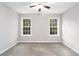 Spacious bedroom with neutral walls and carpet, featuring two large windows at 114 Arborwood Way, Temple, GA 30179