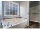 Bathroom with garden tub, tile accent, and walk-in closet at 114 Arborwood Way, Temple, GA 30179