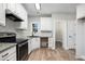 Modern kitchen with white cabinets, granite counters, and stainless steel appliances at 114 Arborwood Way, Temple, GA 30179
