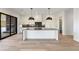 White modern kitchen featuring a waterfall edge island, hardwood floors, and black dome pendant lights at 247 Huntington Ne Rd, Atlanta, GA 30309