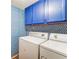 Bright laundry room with blue cabinets and patterned wallpaper at 12 Rumson Ct, Smyrna, GA 30080