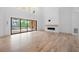 Open living room with hardwood floors, fireplace, and sliding glass doors at 2251 Old Atlanta Rd, Cumming, GA 30041