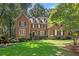 Brick two-story house with a lush green lawn and mature trees at 788 Old Paper Mill Dr, Marietta, GA 30067