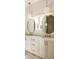 Double vanity bathroom with gold fixtures and oval mirrors at 1180 Lupo Loop, Chattahoochee Hills, GA 30268