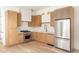 Modern kitchen with light wood cabinets, stainless steel appliances, and quartz countertops at 1180 Lupo Loop, Chattahoochee Hills, GA 30268