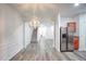 Bright dining room with hardwood floors, modern chandelier, and view into living area at 2158 Executive Dr, Duluth, GA 30096