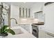 Modern white kitchen with marble island, stainless steel appliances, and gold fixtures at 3630 Peachtree Ne Rd # 3106, Atlanta, GA 30326