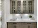 Butlery with gray cabinets, glass doors, quartz countertops, and wine storage at 3759 Tielman St, Snellville, GA 30078