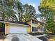 Two-story yellow house with white garage door and landscaping at 8683 Twin Oaks Dr, Jonesboro, GA 30236