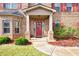 Inviting front entrance with red door, brick columns, and well-maintained landscaping at 235 Silver Ridge Rd, Covington, GA 30016