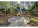 Circular stone firepit surrounded by trees and grass at 5955 Tibor Nw Dr, Acworth, GA 30101