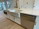 White kitchen island with farmhouse sink, stainless steel appliances, and gold faucet at 2757 Wynberry Se Ln, Atlanta, GA 30339