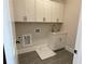 Bright laundry room with white cabinets and gray tile floors at 2757 Wynberry Se Ln, Atlanta, GA 30339