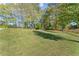 Expansive grassy backyard with trees and wooden fence at 7210 Wallace Tatum Rd, Cumming, GA 30028