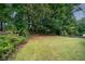 Wooded backyard with a grassy area and privacy fence at 143 Templeton Ln, Villa Rica, GA 30180
