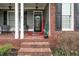 Brick porch with two chairs, a welcome mat, and decorative plants at 143 Templeton Ln, Villa Rica, GA 30180