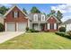 Two-story brick home with a large front yard and driveway at 143 Templeton Ln, Villa Rica, GA 30180