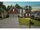 Brick house with a two-car garage and well-manicured lawn at dusk at 143 Templeton Ln, Villa Rica, GA 30180