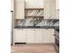 Modern kitchen with white cabinets, marble backsplash, and wood shelves at 1184 Lupo Loop, Chattahoochee Hills, GA 30268