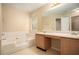 Bathroom with double vanity, soaking tub, and a mirrored medicine cabinet at 4103 Kingship Dr, Ellenwood, GA 30294