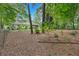 House backyard view with mature trees and a screened porch at 135 Hitchcock Dr, Villa Rica, GA 30180