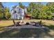 Fire pit area and wooden deck behind two-story home nestled in trees at 364 Whooping Creek Rd, Carrollton, GA 30116