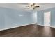 Spacious bedroom with a ceiling fan, light blue walls, and dark laminate wood floors at 379 Red Maple Way, Dallas, GA 30157