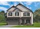 Two story house with gray siding, stone accents, and a gray three car garage at 277 Silver Leaf Trl, Douglasville, GA 30134